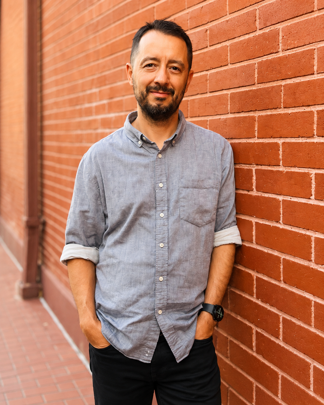 Pastor Juan Gil, junto a una pared de ladrillos